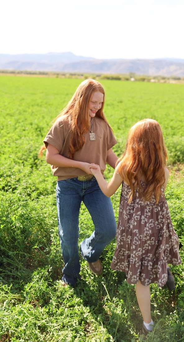 Dallie and Reinsley walking through the alfalfa