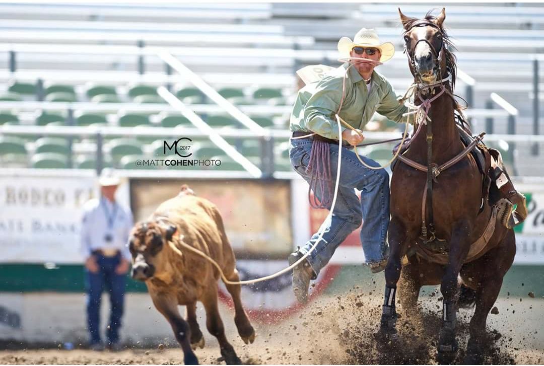 Trampus Quarnberg stepping off his horse after roping a calf at the 2017 Reno Rodeo